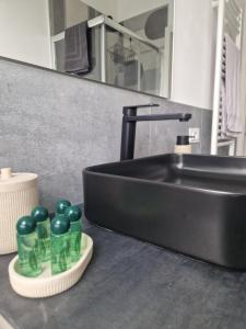 a bathroom sink with green bottles on a counter at House 13 apartment in Cernobbio in Cernobbio +21 photos