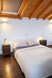 a bedroom with a white bed and two night stands at Casa di Cocco in Alzano Lombardo