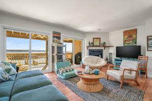 a living room with a couch and a table at Channel Winds - Waterfront Bliss & Lighthouse Views! in Birch Town