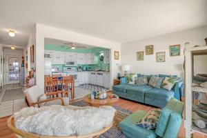 a living room with a blue couch and a kitchen at Channel Winds - Waterfront Bliss & Lighthouse Views! in Birch Town