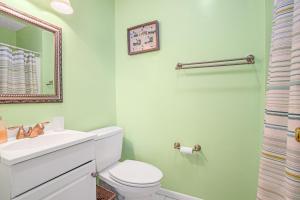 a bathroom with a white toilet and a sink at Channel Winds - Waterfront Bliss & Lighthouse Views! in Birch Town +34 photos