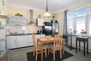 a kitchen with a wooden table and chairs at fewo1846 - Artemis - vintage Altbau-Wohnung im 4 OG eines Geschäftshauses im Stadtzentrum in Flensburg