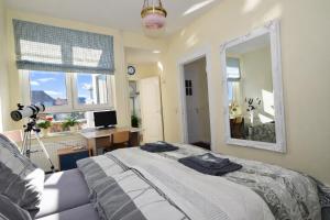 a bedroom with a bed and a desk and a mirror at fewo1846 - Artemis - vintage Altbau-Wohnung im 4 OG eines Geschäftshauses im Stadtzentrum in Flensburg