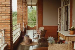 a porch with two chairs and a table and a window at Amatacasa Villa Rosa in Melfi