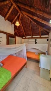 a bedroom with two beds in a room with wooden ceilings at Hotel Viejamar con Cocina compartida in Puerto López +15 photos