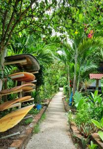 a path in a garden with wooden surfboards at Hotel Viejamar con Cocina compartida in Puerto López