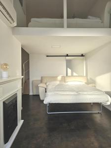 a white bedroom with a bed and a fireplace at Galerie Apartment Leon in Kippenheim