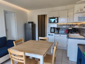 a kitchen with a table and chairs in a room at T2 L'orée du Golf labellisé 3 étoiles - Terasse et Parking in Pornic