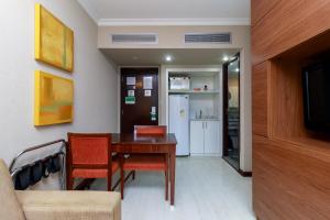 a dining room with a table and chairs and a kitchen at Flat Luxo Verbo Divino 6 in São Paulo