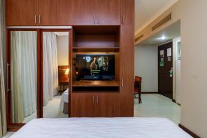 a bedroom with a tv in a wooden entertainment center at Flat Luxo Verbo Divino 6 in São Paulo