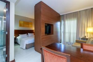 a hotel room with a bed and a desk and a room at Flat Luxo Verbo Divino 6 in São Paulo +16 photos
