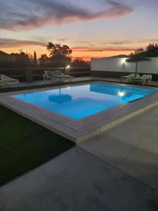 a swimming pool with a sunset in the background at Alojamiento GUADALENTIN in Pozo Alcón