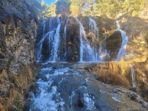 a waterfall on the side of a rocky cliff at Alojamiento GUADALENTIN in Pozo Alcón