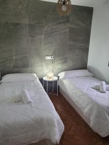 a bedroom with two beds and a side table at Alojamiento GUADALENTIN in Pozo Alcón
