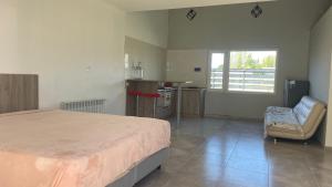 a bedroom with a bed and a chair and a window at Mi casa es tu casa Loft in Malargüe
