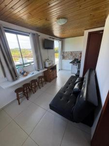 a living room with a black couch and a table at Pousada Mahara - Praia do Rosa in Imbituba