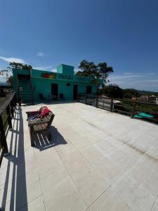 a building with a bench in the middle of a patio at Pousada Mahara - Praia do Rosa in Imbituba