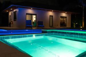 a swimming pool in front of a house at night at Romantic Guest House · Heated Spa & Pool · Private Retreat in Fort Lauderdale