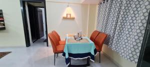a table with orange chairs and a blue table cloth on it at Spacious 2BHK flat in new panvel in Navi Mumbai