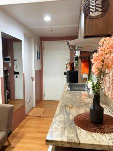 a kitchen with a table with a vase of flowers on it at Sunvida Tower Corner Suite Across SM Cebu in Cebu City +9 photos