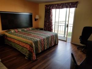 a hotel room with a bed and a large window at Espana Motel in Norwalk +14 photos