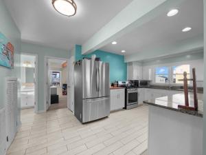 a large kitchen with a stainless steel refrigerator at No Work Zone in North Topsail Beach