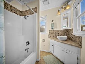 a bathroom with a tub and a sink and a shower at No Work Zone in North Topsail Beach