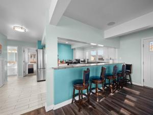 a kitchen with a blue counter and chairs at No Work Zone in North Topsail Beach +38 photos