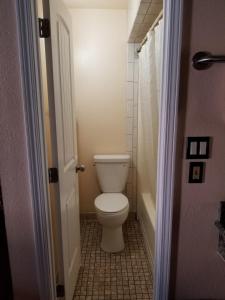 a bathroom with a toilet and a bath tub at Espana Motel in Norwalk