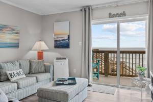 a living room with a couch and a view of the ocean at Feel the Sea Breezes in North Topsail Beach
