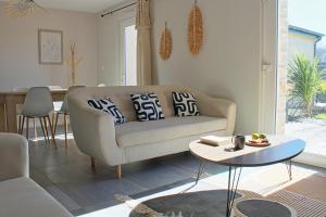 a living room with a couch and a table at Iconic, Spa, sauna & terrasse in Trégastel