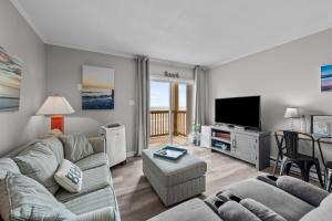 a living room with a couch and a television at Feel the Sea Breezes in North Topsail Beach