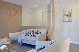 a living room with a couch and a chair at Iconic, Spa, sauna & terrasse in Trégastel
