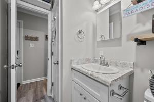 a white bathroom with a sink and a mirror at Feel the Sea Breezes in North Topsail Beach +19 photos
