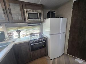 a kitchen with a white refrigerator and a microwave at Catchin Rays in North Topsail Beach
