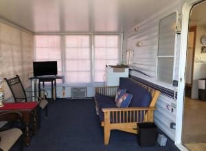a room with a couch and a desk with a computer at Cozy Camper NTB in North Topsail Beach
