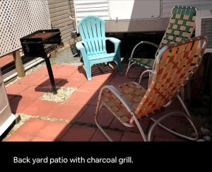 two rocking chairs and a grill on a patio at Cozy Camper NTB in North Topsail Beach