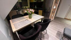 a kitchen with a table with a vase of flowers on it at Veløyveien 4b in Sandefjord +6 photos