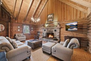 a living room with a fireplace in a log cabin at Townsend Charm: River View Historic Log Cabin! in Townsend