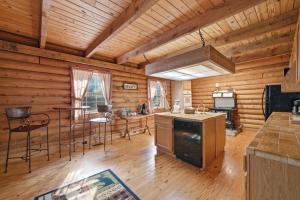a kitchen in a log cabin with a table and chairs at Townsend Charm: River View Historic Log Cabin! in Townsend