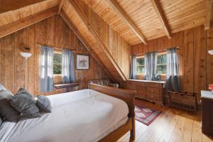 a bedroom with a bed in a room with wooden walls at Townsend Charm: River View Historic Log Cabin! in Townsend