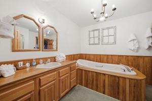 a bathroom with a tub and a sink and a mirror at Townsend Charm: River View Historic Log Cabin! in Townsend +55 photos