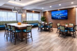 a dining room with tables and chairs and a tv at Best Western Cy-Fair in Houston