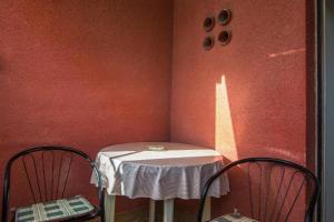 a small table with two chairs in a room at Room Peričić in Strožanac