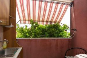 a bathroom with a window with a plant in it at Room Peričić in Strožanac