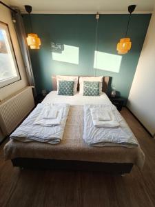 a bedroom with a bed with two towels on it at Het Dobbertje, charmant houten huisje in Sint Maartensvlotbrug