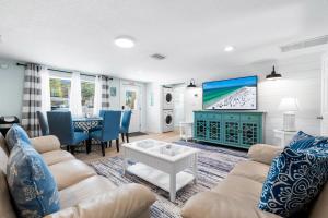 a living room with a couch and a tv at Star Fish 3 Bed 2 bath POOL Walk to Beach in Sarasota