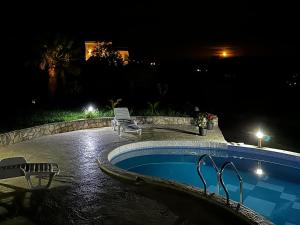 a swimming pool at night with two chairs next to it at Villa 11 Infinity pool & garden in Dobra Voda