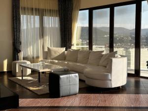 a living room with a white couch and a table at Villa 11 Infinity pool & garden in Dobra Voda