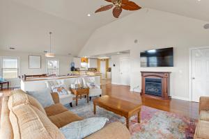 a living room with a couch and a fireplace at Sounds Like A Plan in Kill Devil Hills